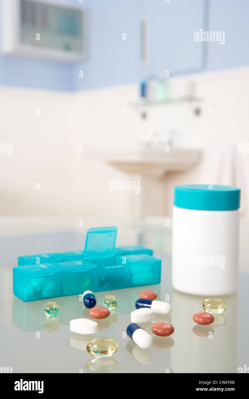 Pills and organiser in bathroom Stock Photo