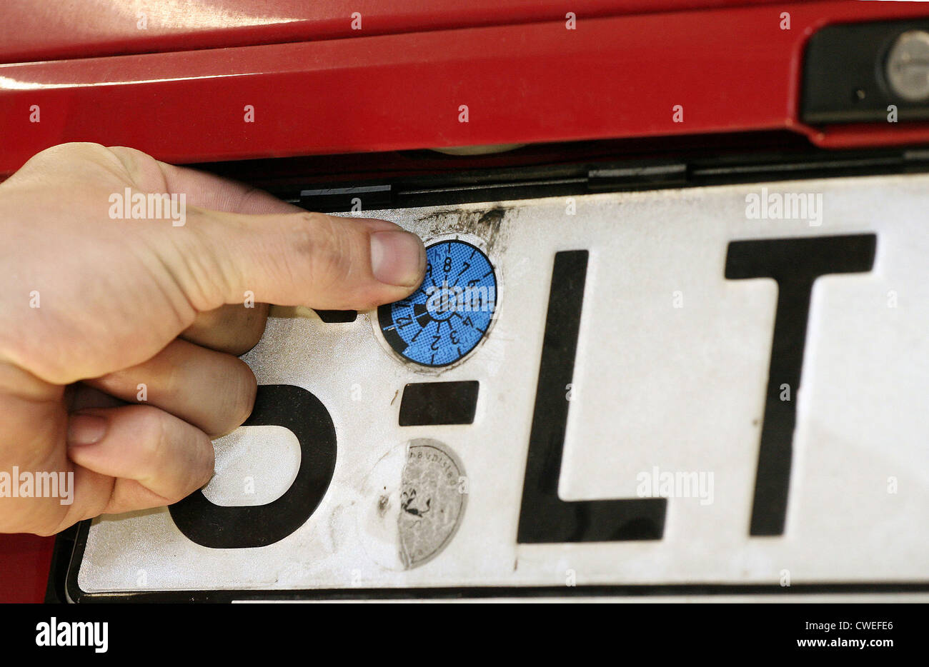 MOT Testing - sticking the new inspection sticker on the rear vehicle Stock Photo