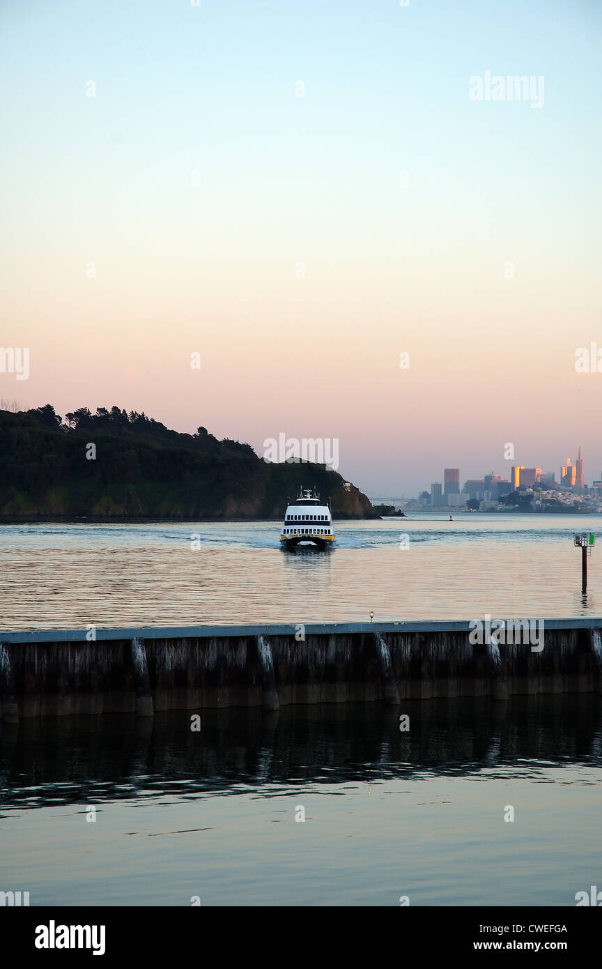 A ferry on San Francisco Bay approaching Tiburon's marina in Marin County, California, USA. Angel Island is in the background. Stock Photo