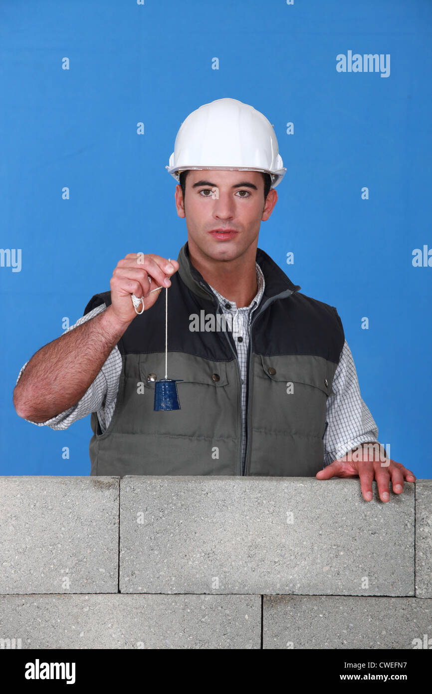 Mason using tool to check wall Stock Photo Alamy