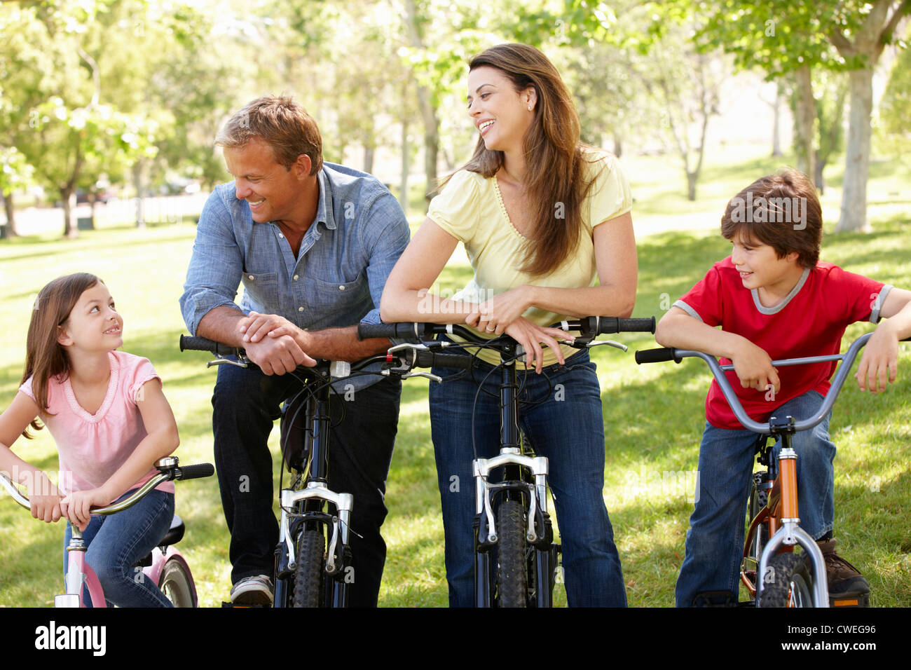 Family riding bikes in park Stock Photo