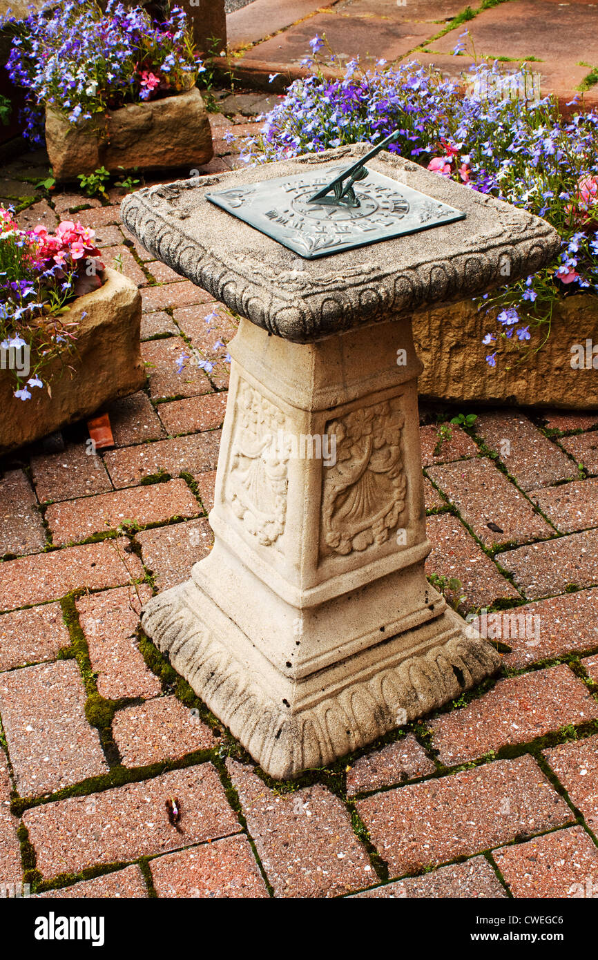 ornamental sundial in a small paved garden Stock Photo
