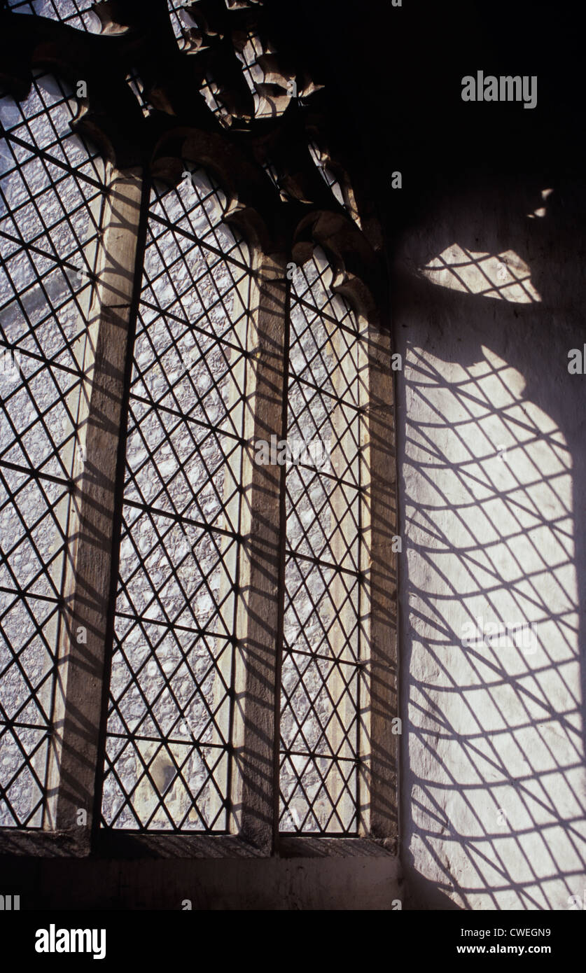 Detail of large clear diamond-leaded 15th century Gothic Perpendicular church window with shadows Stock Photo