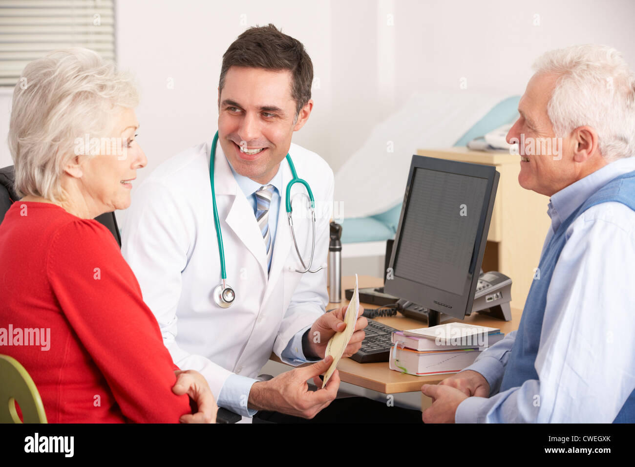 American doctor talking to senior couple in surgery Stock Photo