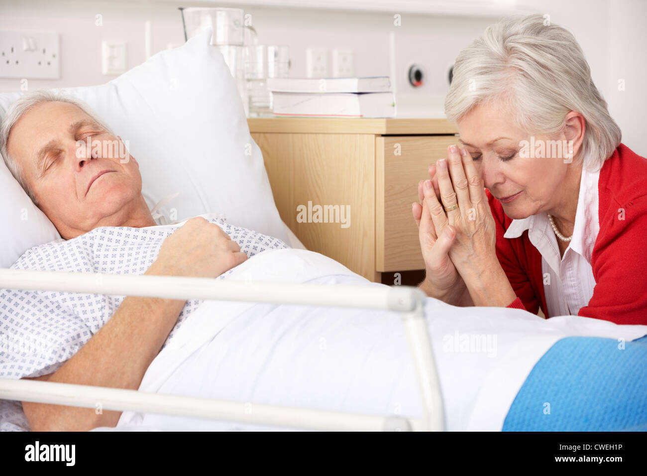 Senior woman with seriously ill husband in hospital Stock Photo