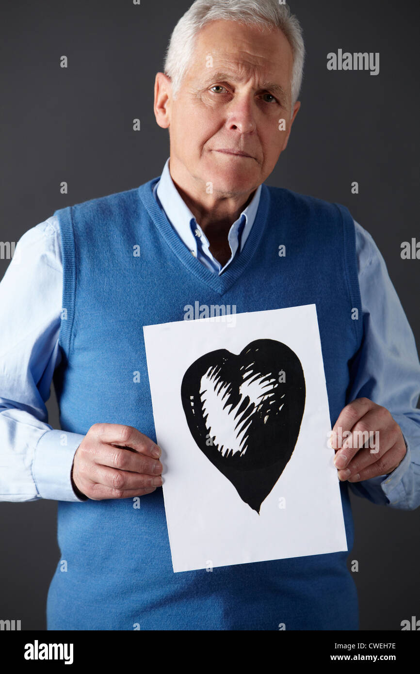 Senior man holding ink drawing of heart Stock Photo