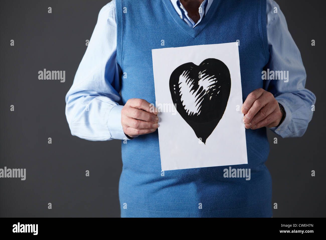 Senior man holding ink drawing of heart Stock Photo