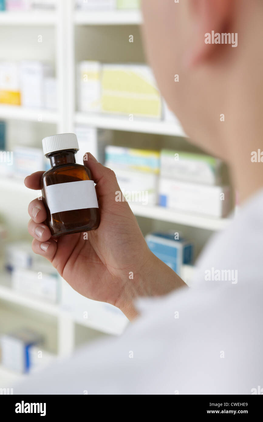 Pharmacist holding prescription pill bottle Stock Photo