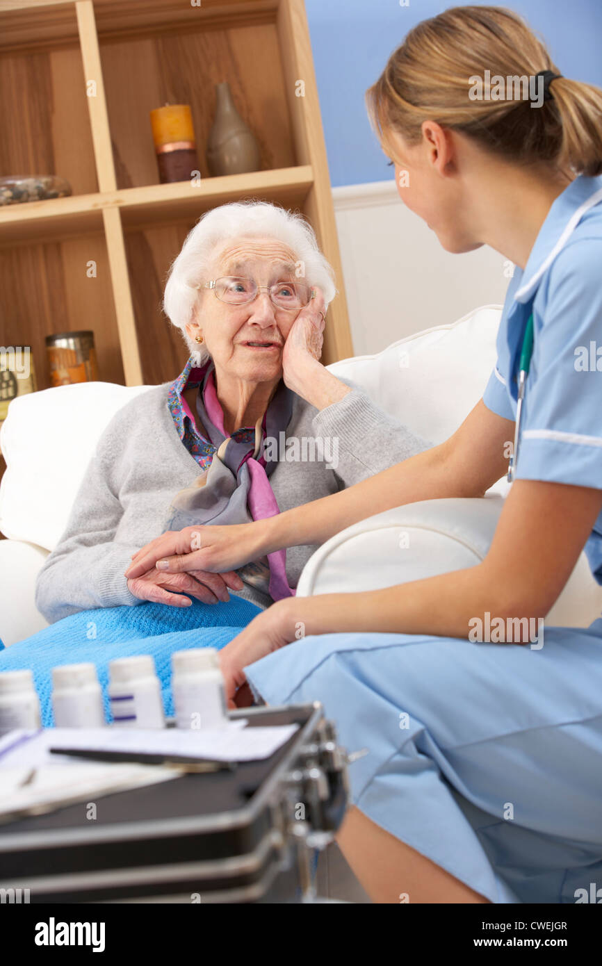 UK nurse visiting senior woman at home Stock Photo