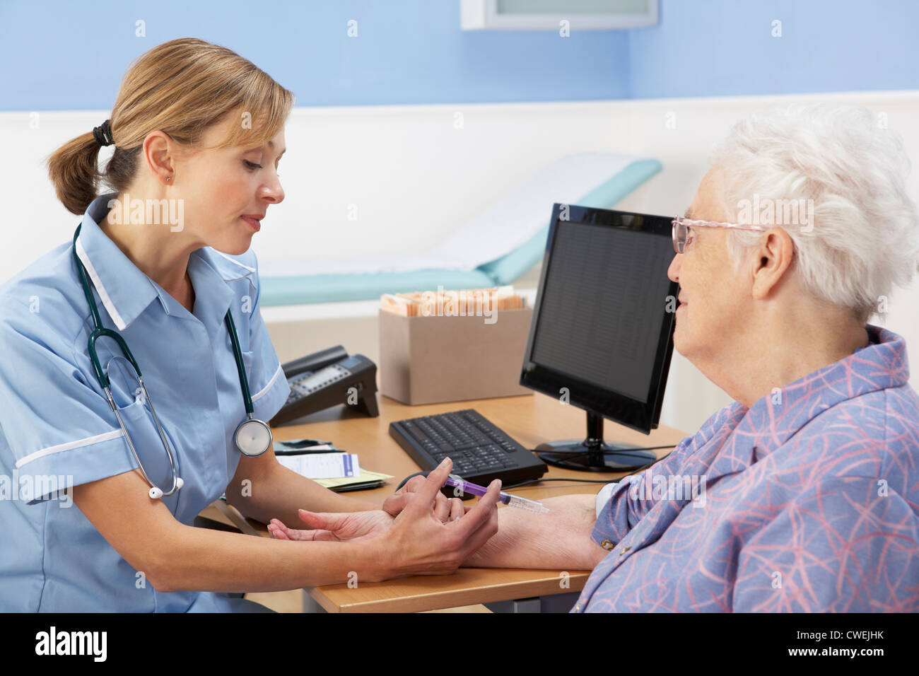 UK nurse injecting senior woman patient Stock Photo