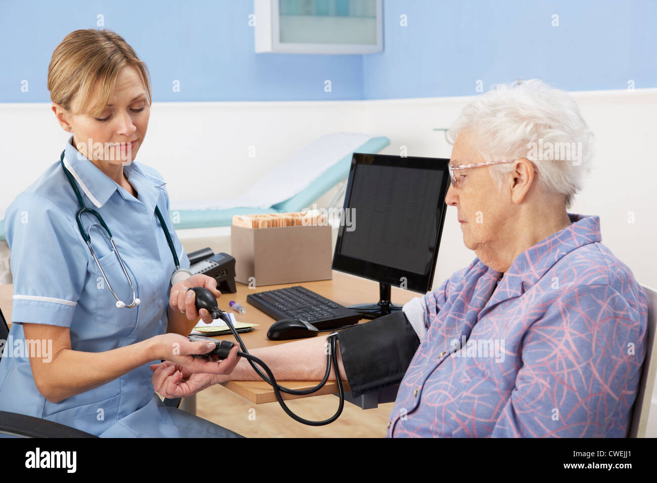 UK nurse taking senior woman's blood pressure Stock Photo