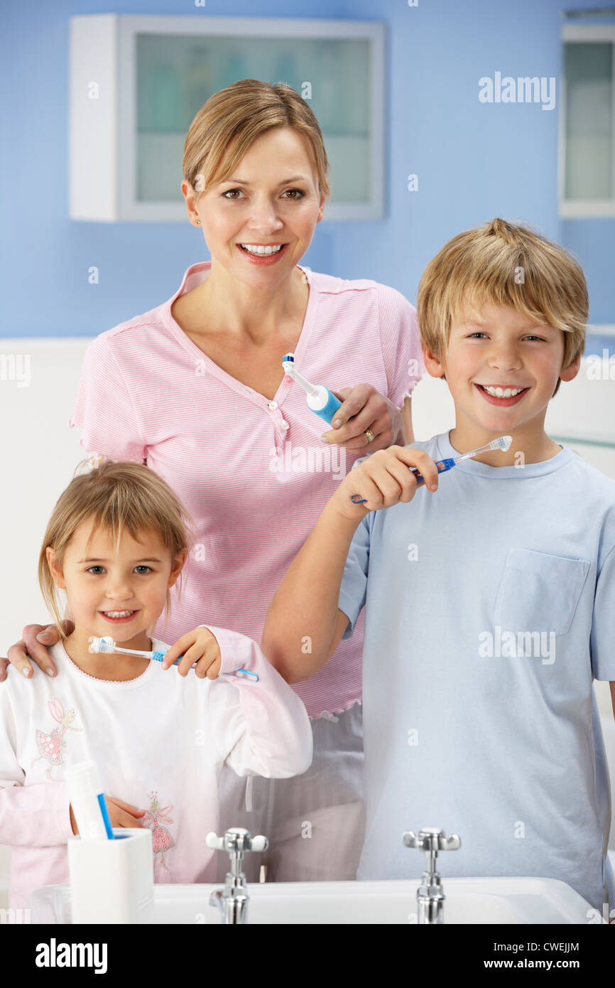 Mother and children cleaning teeth in bathroom Stock Photo - Alamy
