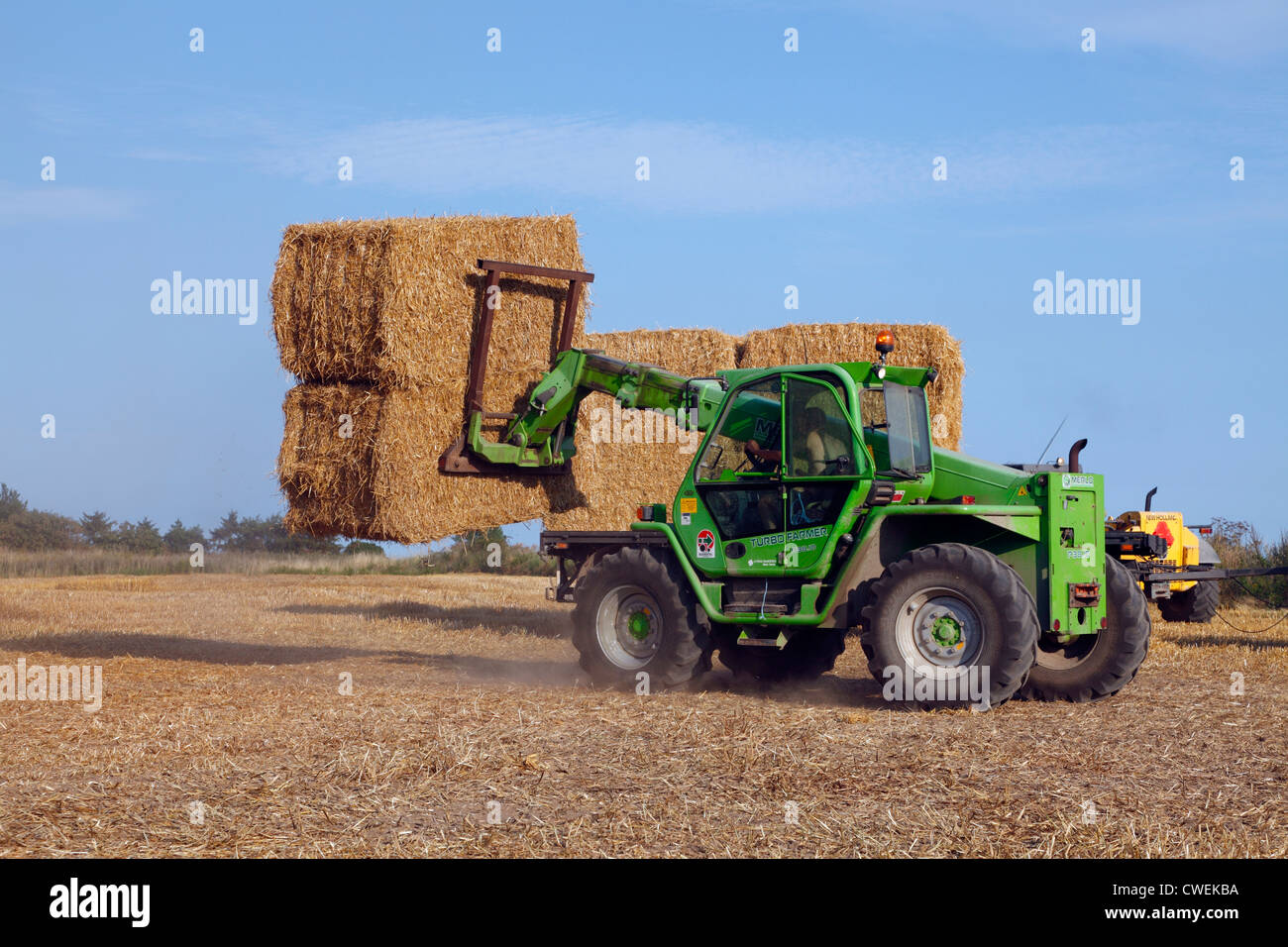 Turbofarmer lift stacking big straw bales on a field in Lynge, North Zealand. Straw bales to be used as biofuel at CHP plant. Heston bales. Stock Photo