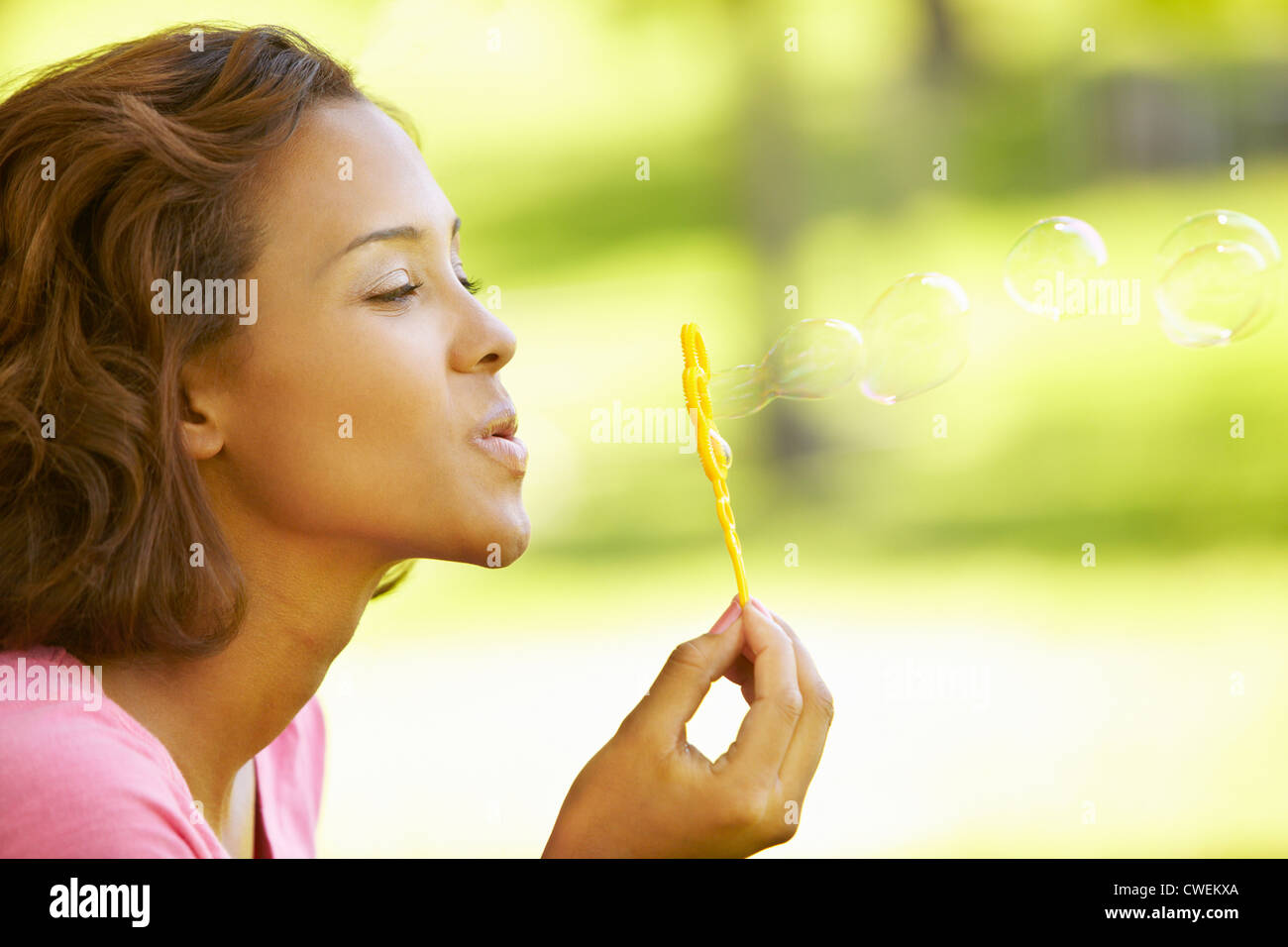 Young woman blowing bubbles Stock Photo - Alamy