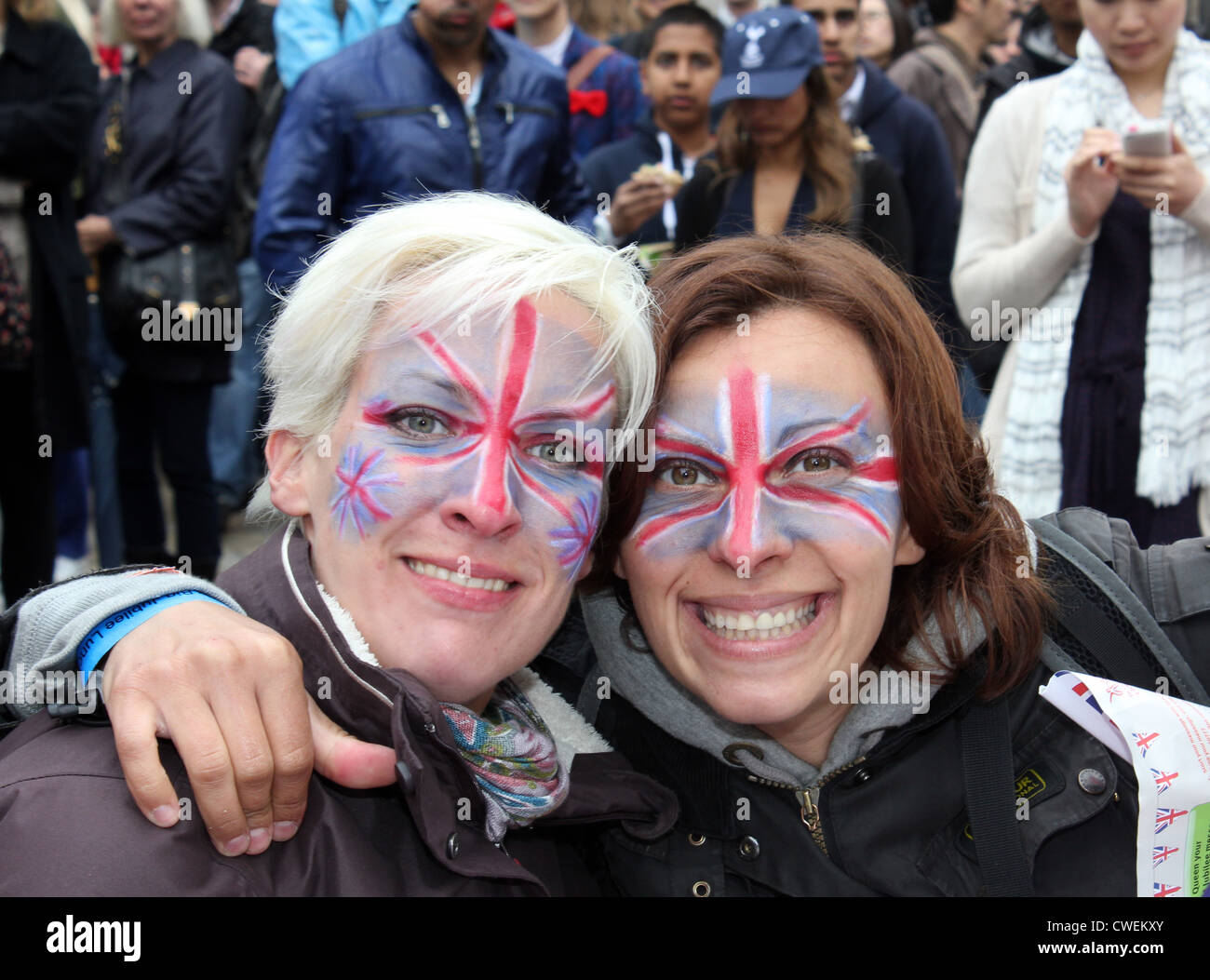 Two women smiling at camera with faces painted with a union jack. Celebrations at the Queen's Diamond Jubilee London, 2012 Stock Photo