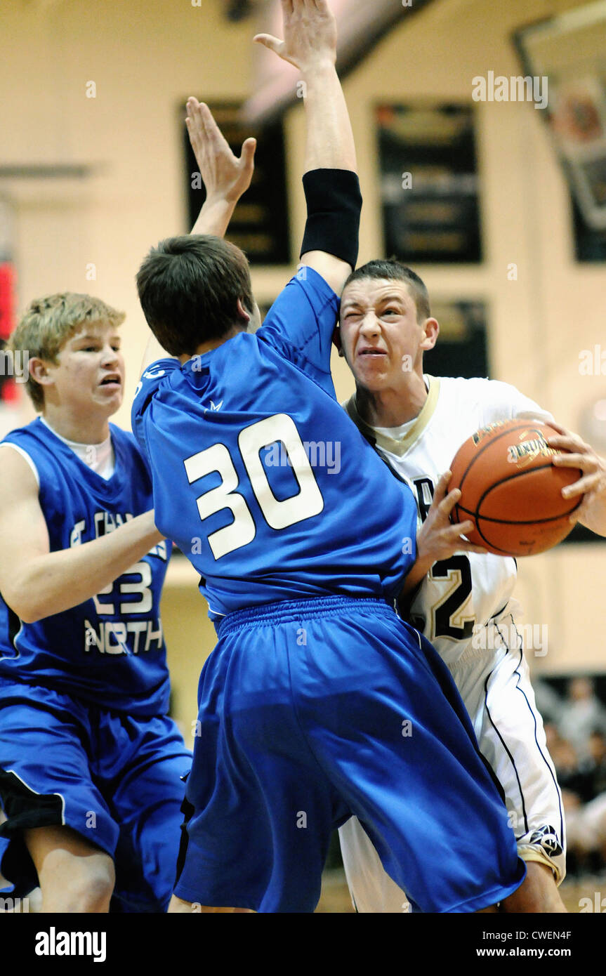 Basketball player meets with some resistance in the paint in the form of an immovable defender during a high school game. USA. Stock Photo