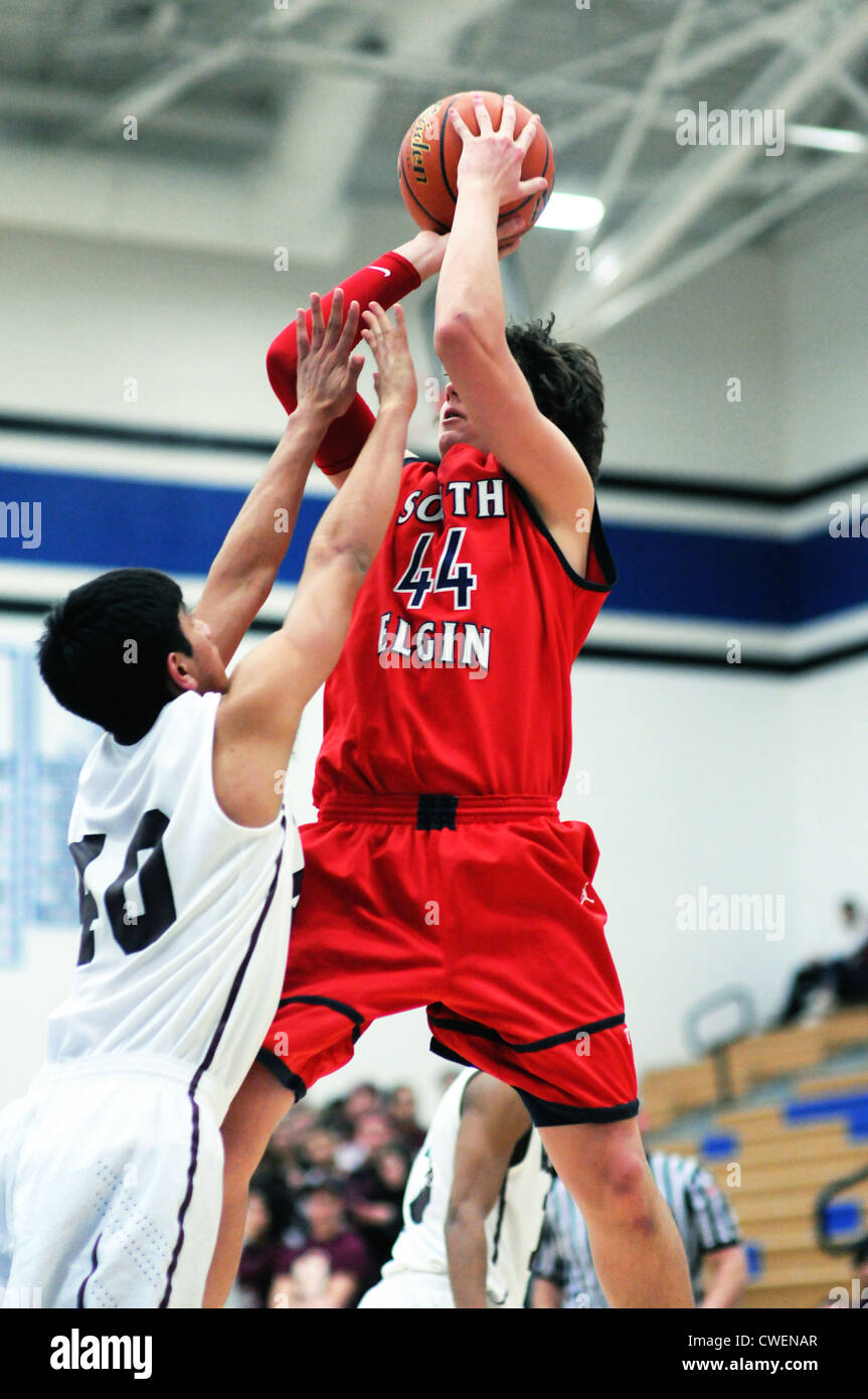 Basketball high school players rises well above the defense to trigger a 15-foot jumper. Stock Photo