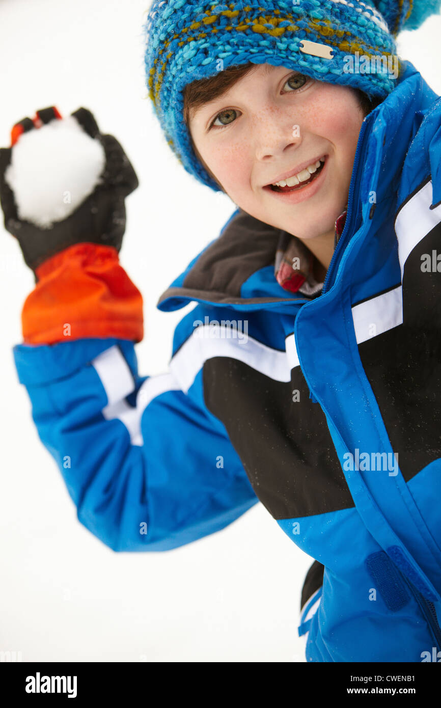 Young Boy About To Throw Snowball Wearing Woolly Hat Stock Photo