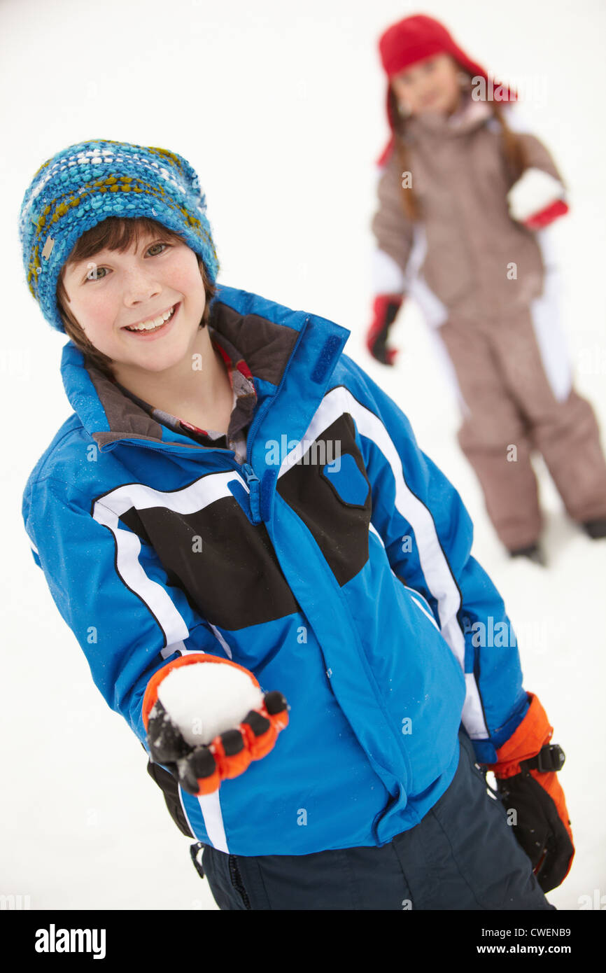 Two Young Children Having Snowball Fight Wearing Woolly Hats Stock Photo
