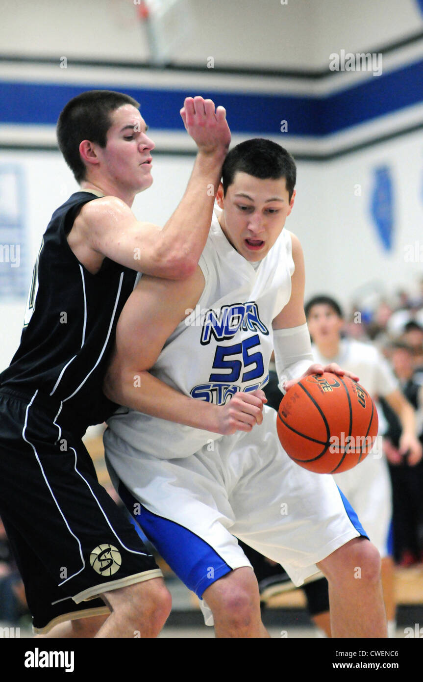 Basketball Player posts up close to the basket and an opponent during a high school game. Stock Photo