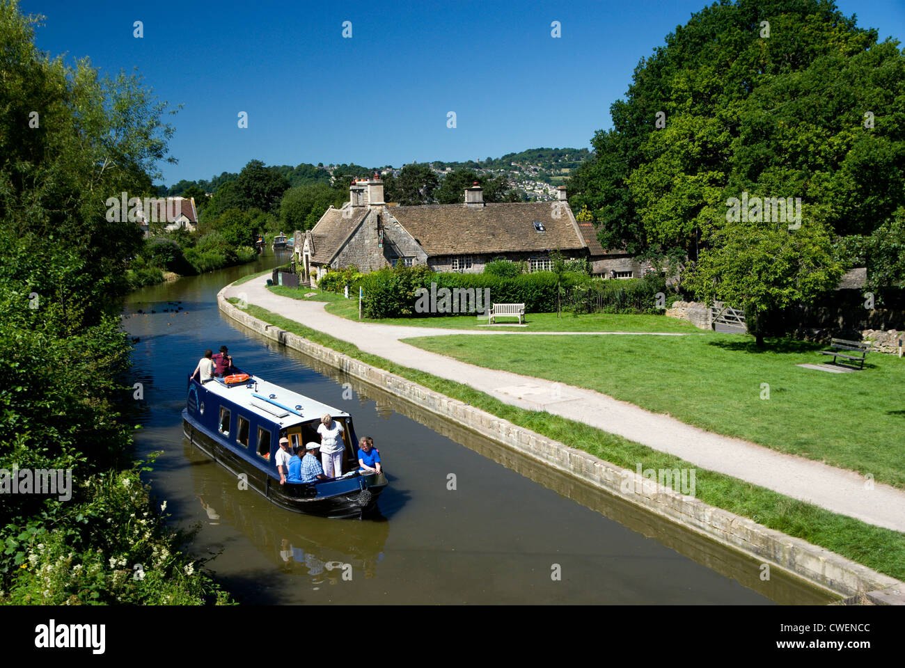 Narrow boat sailing past the George Inn on the Kennet and Avon Canal, Bathampton near Bath, Somerset, England. Stock Photo