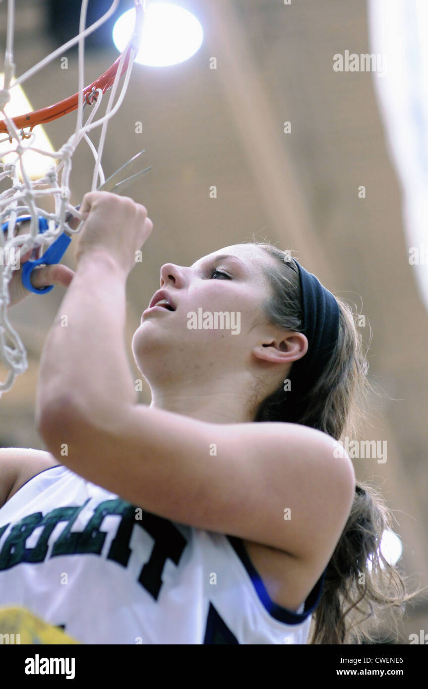Basketball Player  tradition of cutting down the net following the winning of a high school regional championship Stock Photo