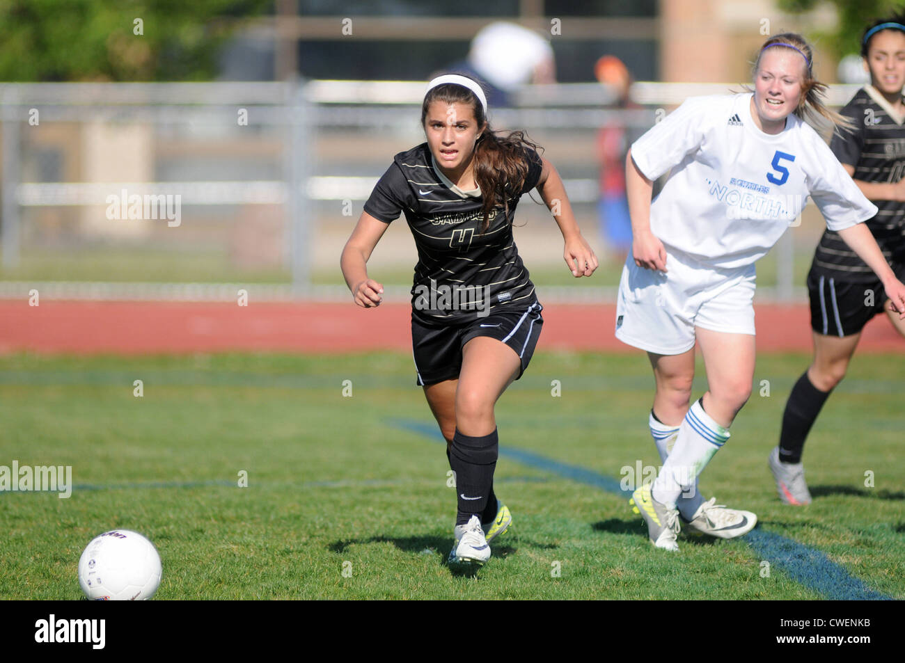 Soccer player rushes after a loose ball to secure the ball during a high  school match. USA Stock Photo - Alamy