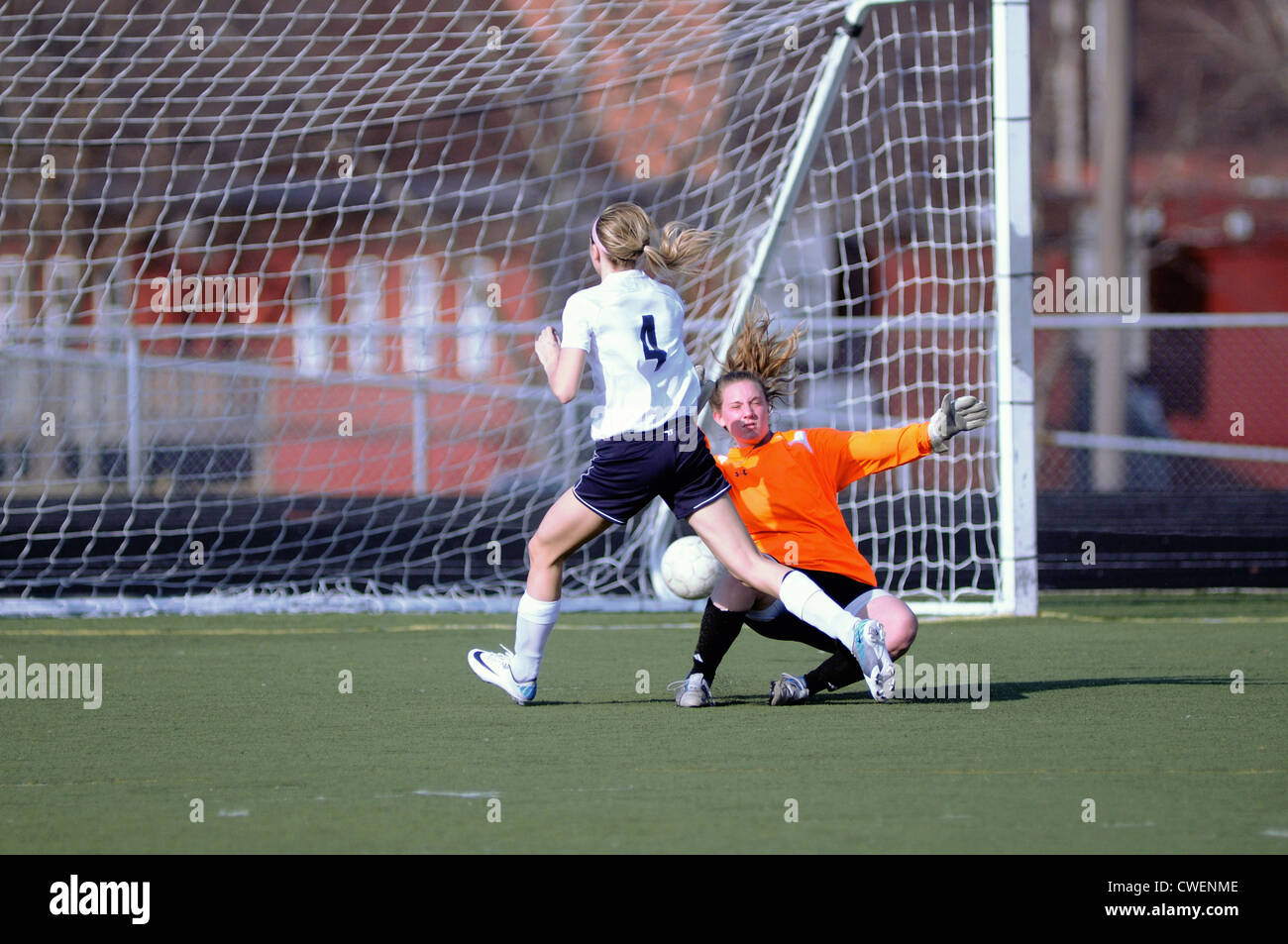 Soccer Player scores as she fires a shot past the keeper from close range. USA. Stock Photo