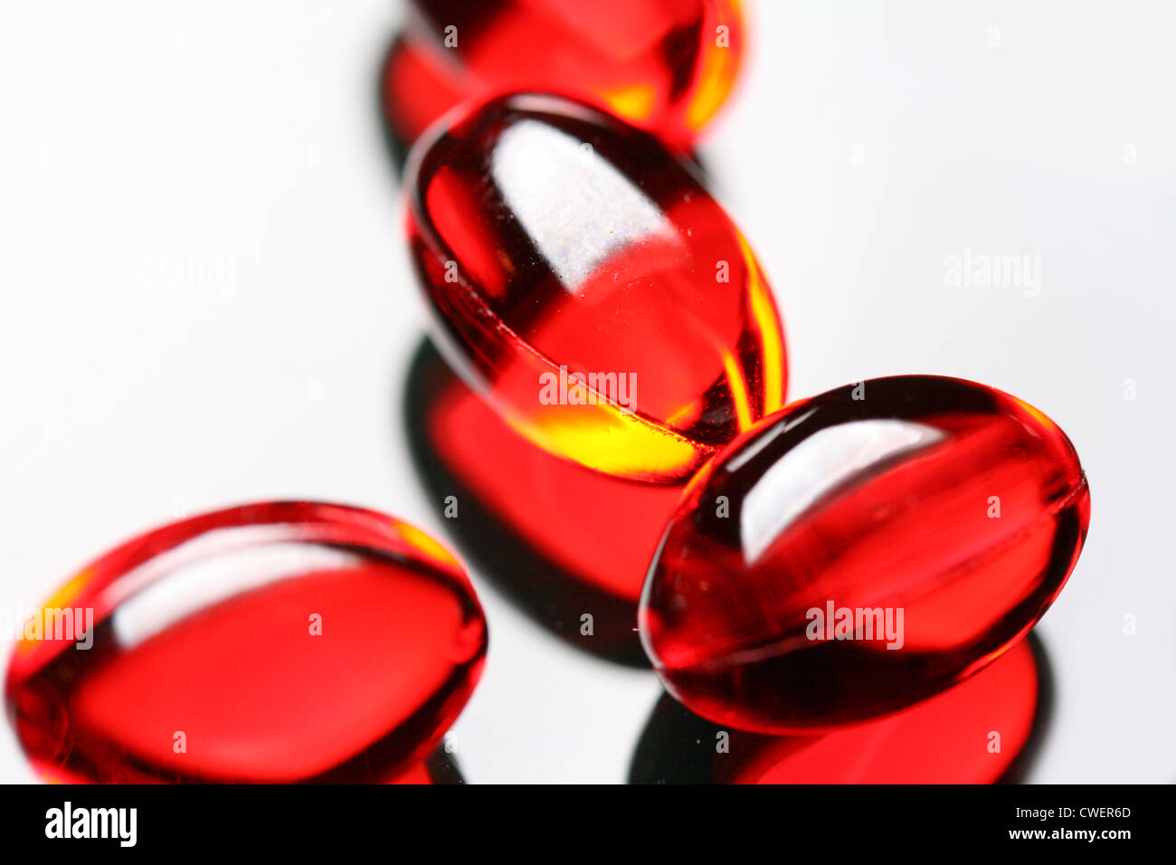 close-up of gel vitamin E supplement capsules on mirror background Stock Photo
