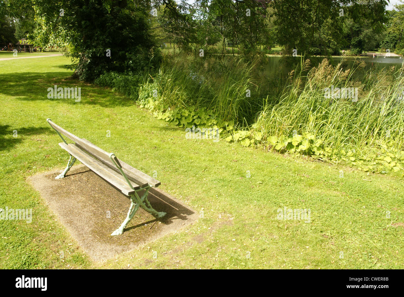 Park bench next to Mere lake in Ellesmere Shropshire Stock Photo