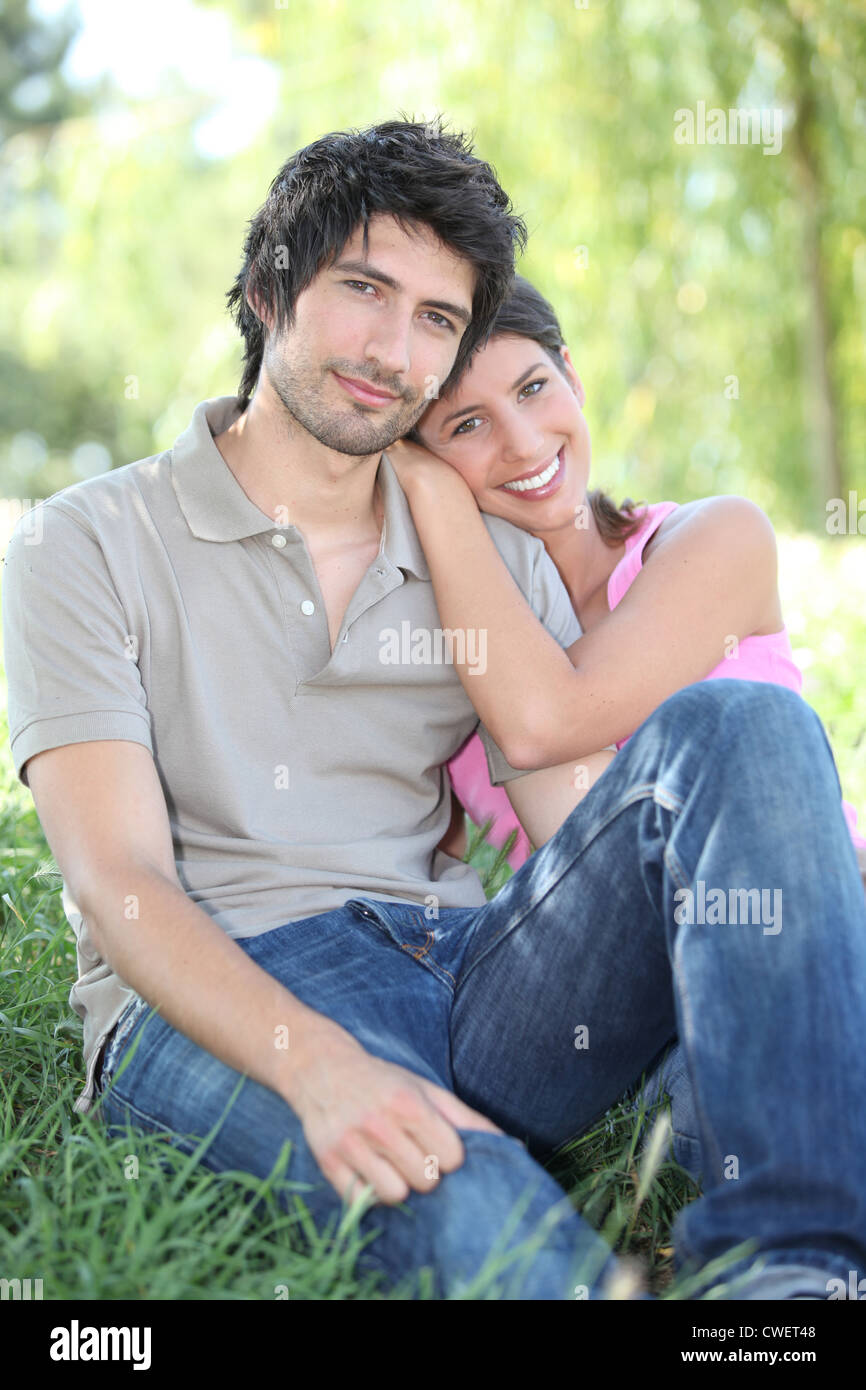 Couple sitting on grass Stock Photo - Alamy