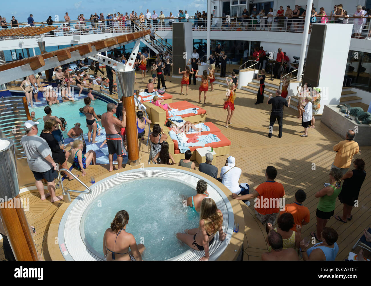 Top deck on a cruise ship with dancers celebrating the departure from port Stock Photo