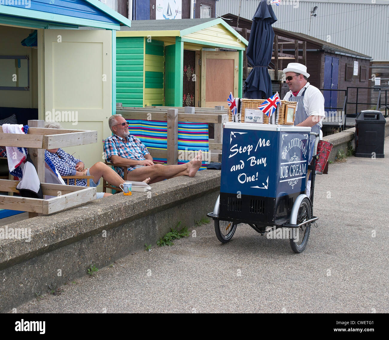 Ice Cream Man. Stop Me and Buy One. Holidaymakers Whitstable Beach Huts Stock Photo