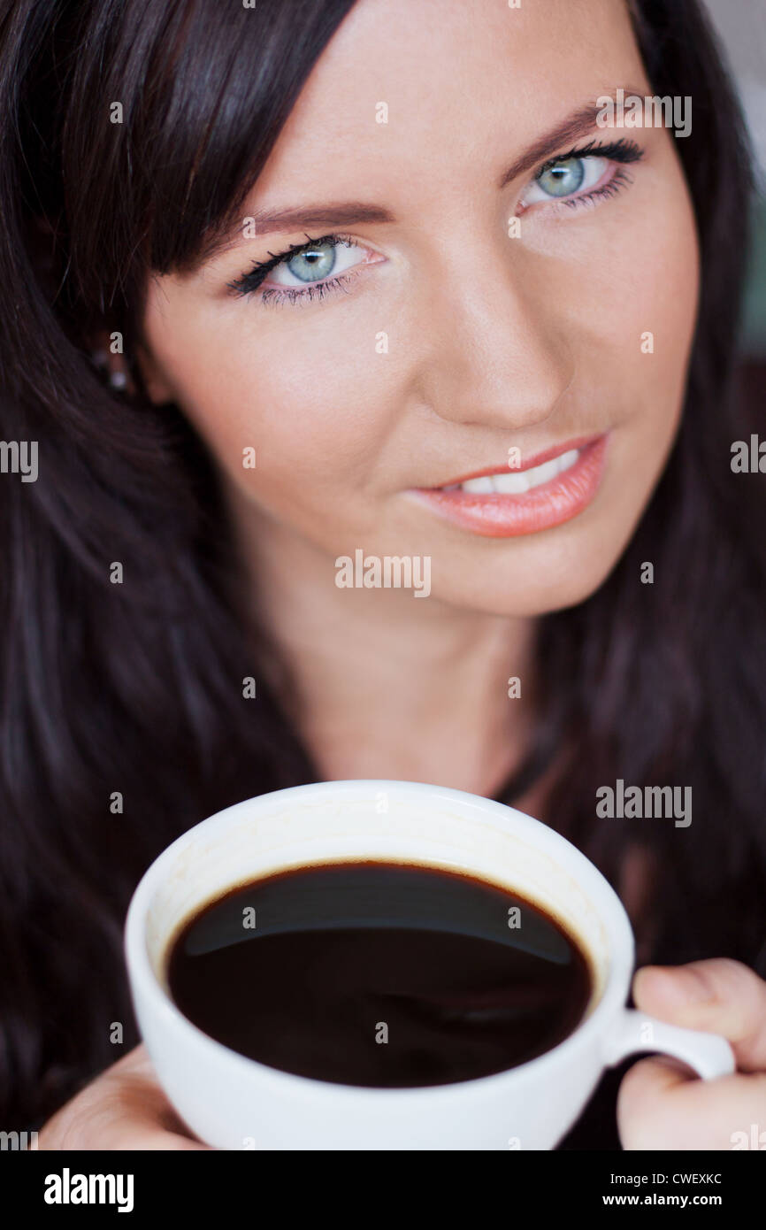 Brunette woman enjoying a cup of black coffee Stock Photo