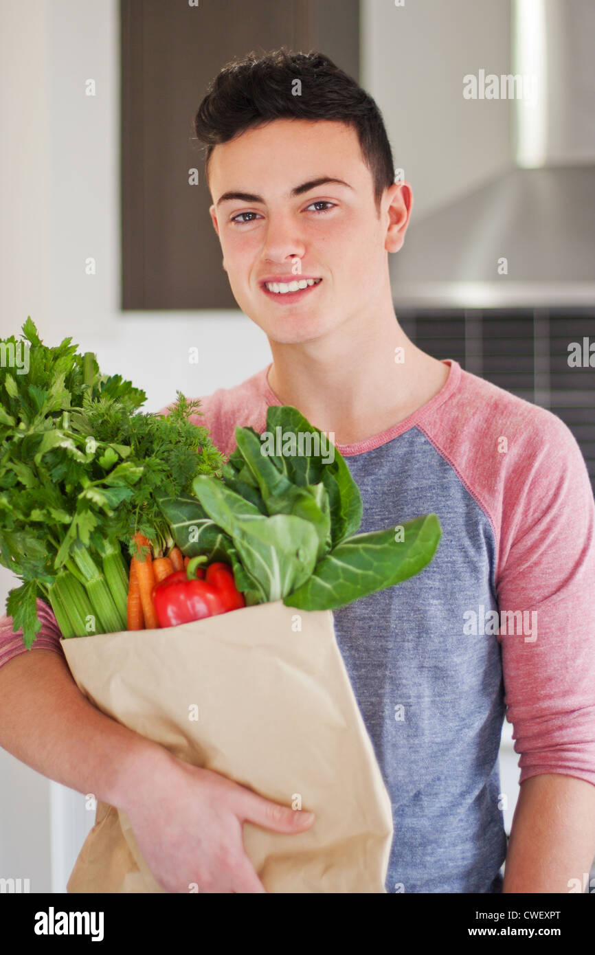 Good looking young man holding bag of fresh groceries Stock Photo