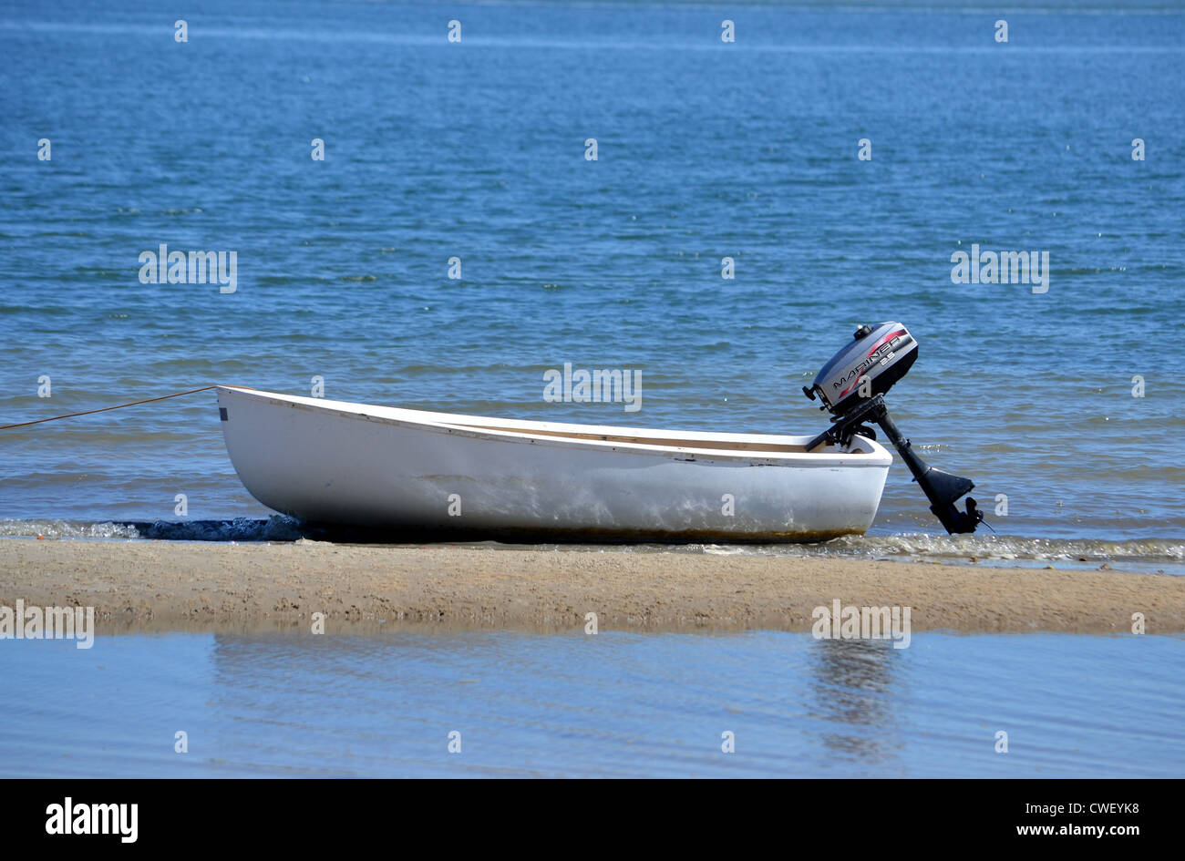small dingy with outboard motor anchored on the shoreline Stock Photo