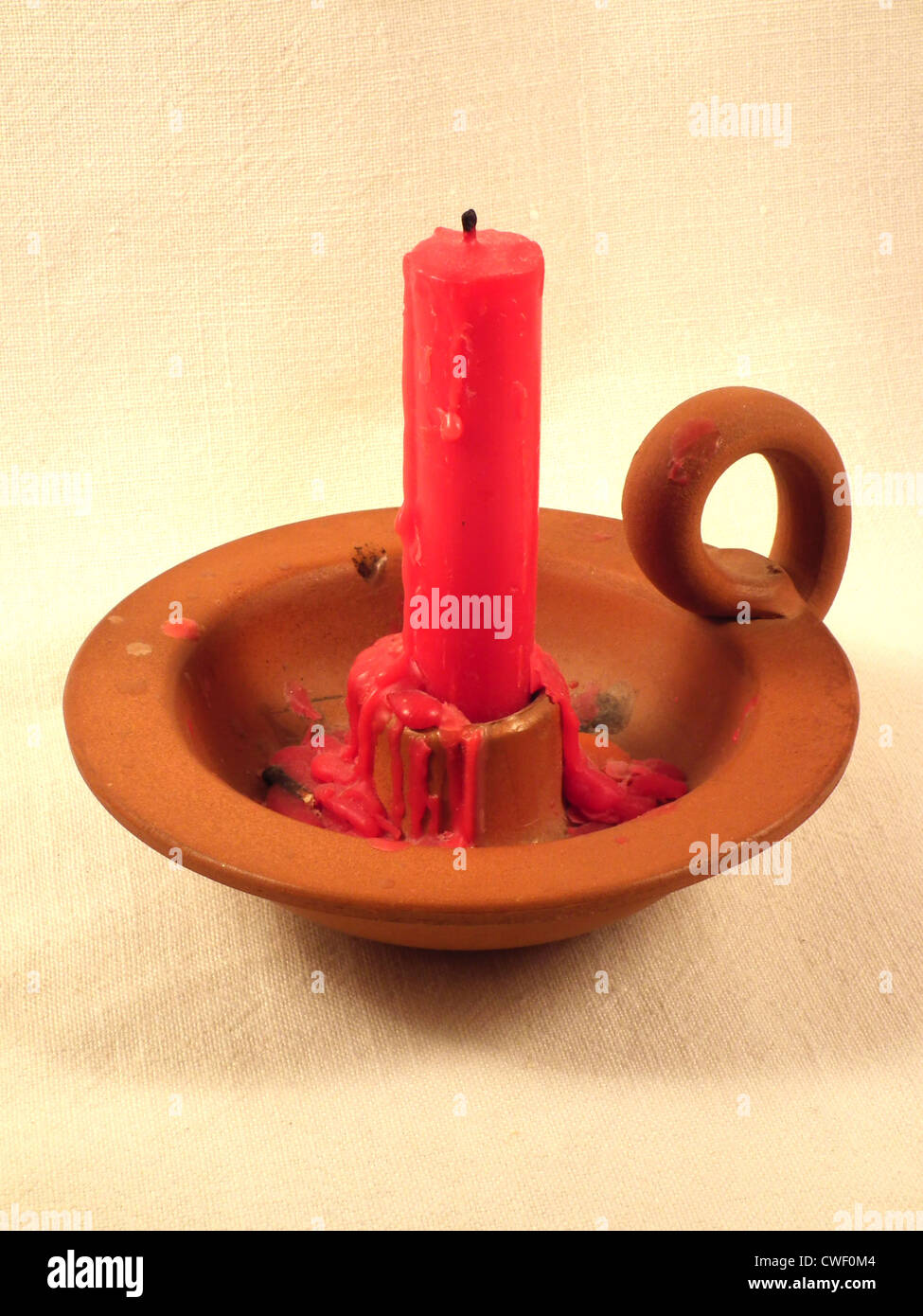 Red candle with a simple brown candelabra Stock Photo