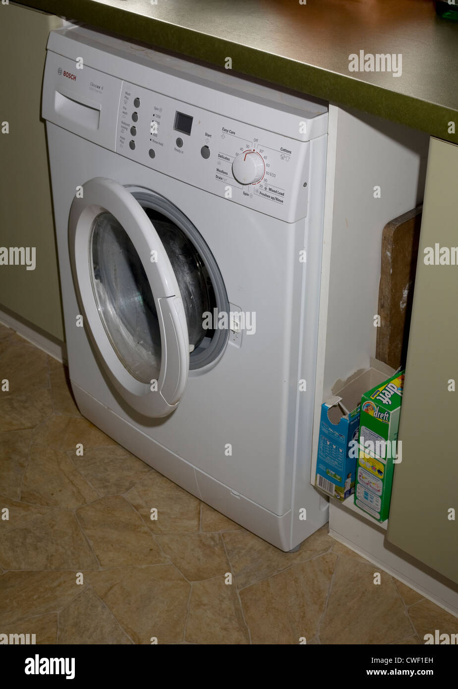 A Bosch 1200 express washing machine neatly tucked under a kitchen surface  with a box of Dreft detergent nearby Stock Photo - Alamy