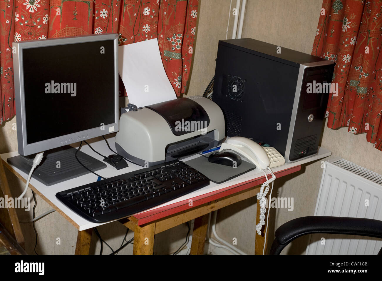 Computer workstation with keyboard, printer and telephone in study ...
