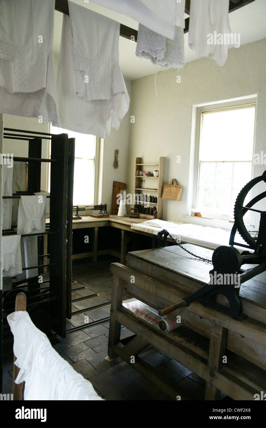 Old fashioned laundry complete with mangle drying racks and linen Stock Photo