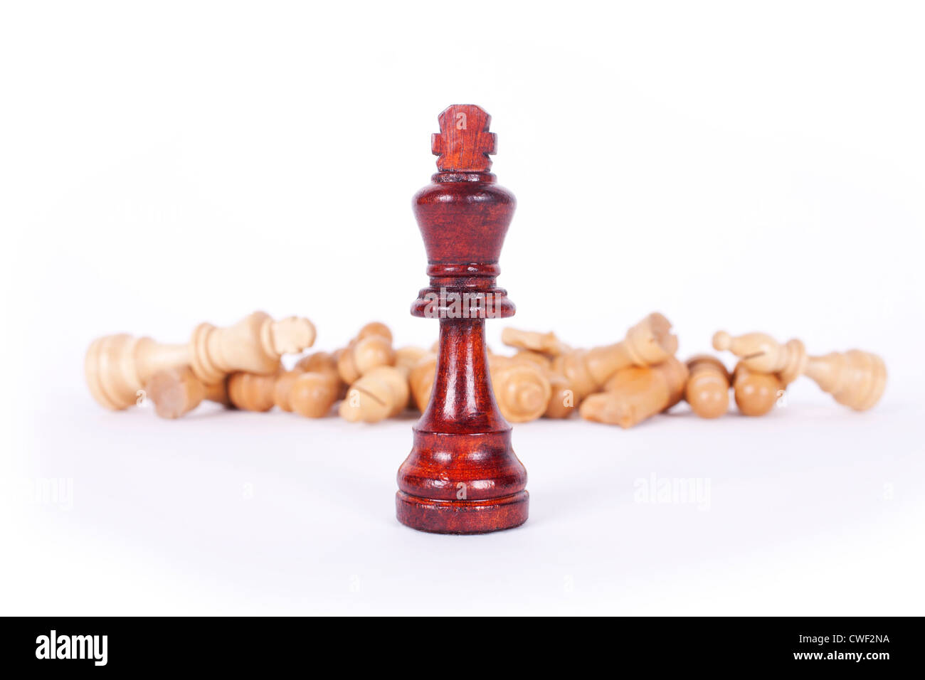 King chess piece stands triumphant in front of white army. Stock Photo