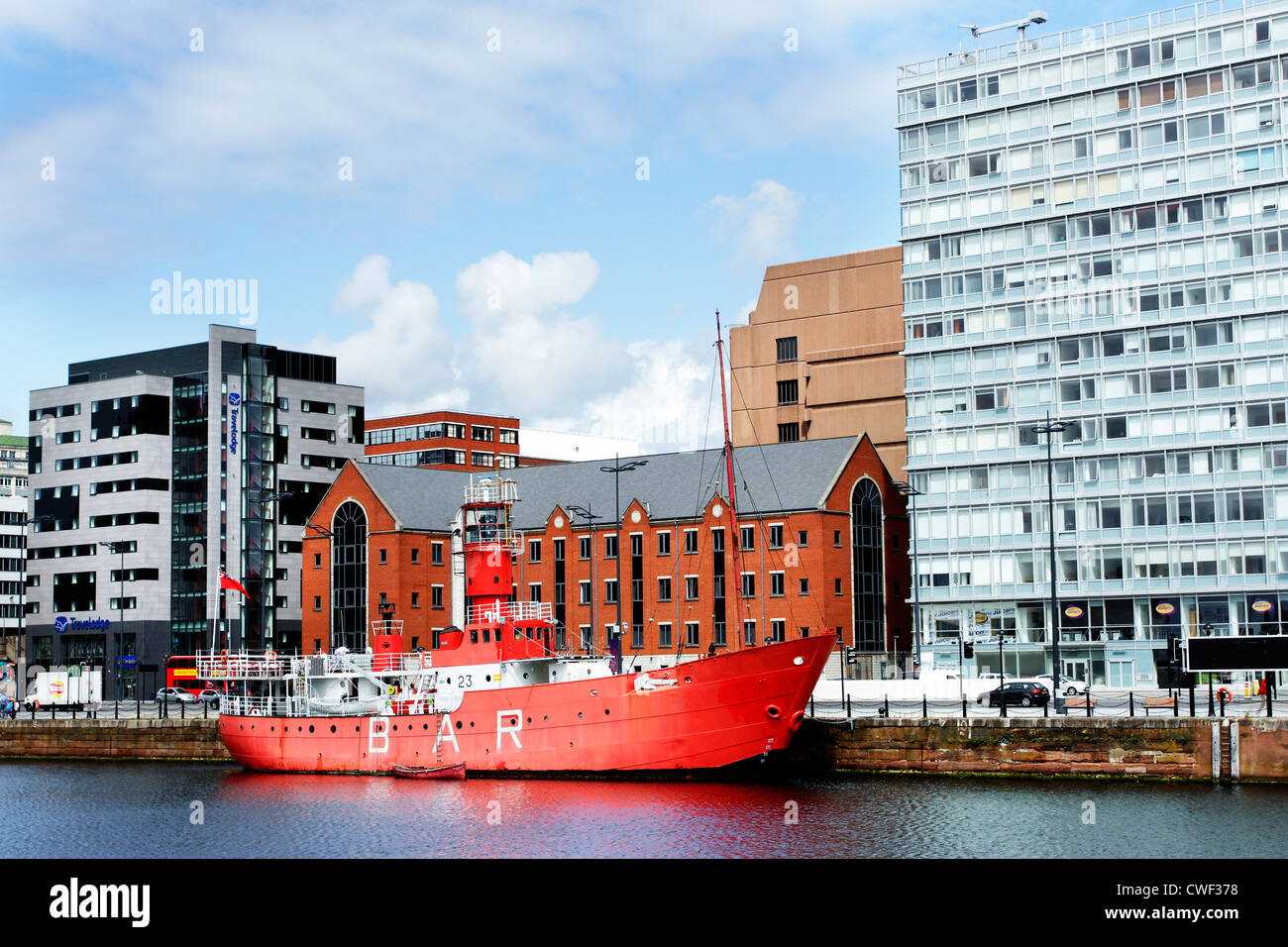 Lightship moored alongside the Albert Dock in Liverpool, Merseyside, in front of modern office buildings. Stock Photo