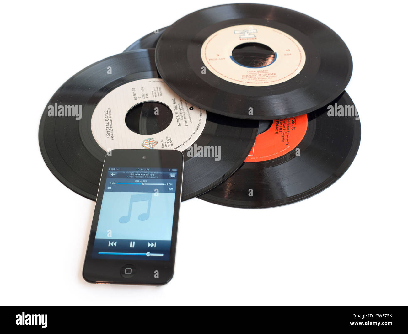 Records and iPod. An iPod sits on a pile of dusty 45rpm records. Stock Photo