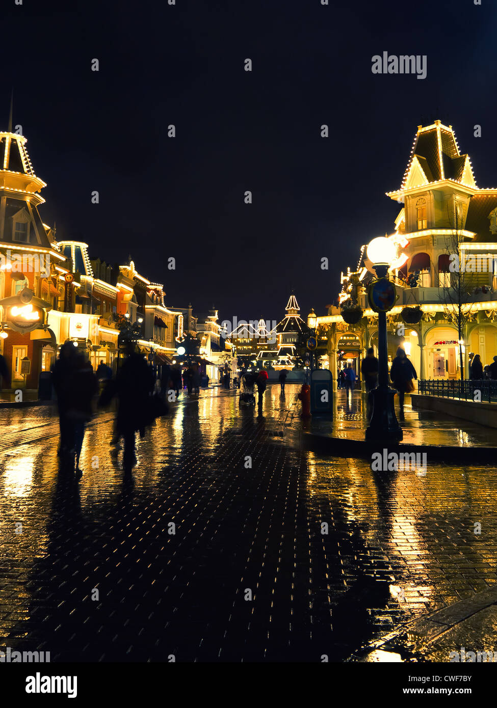 Main street at Disneyland Paris illuminated in the rain at night, Stock Photo