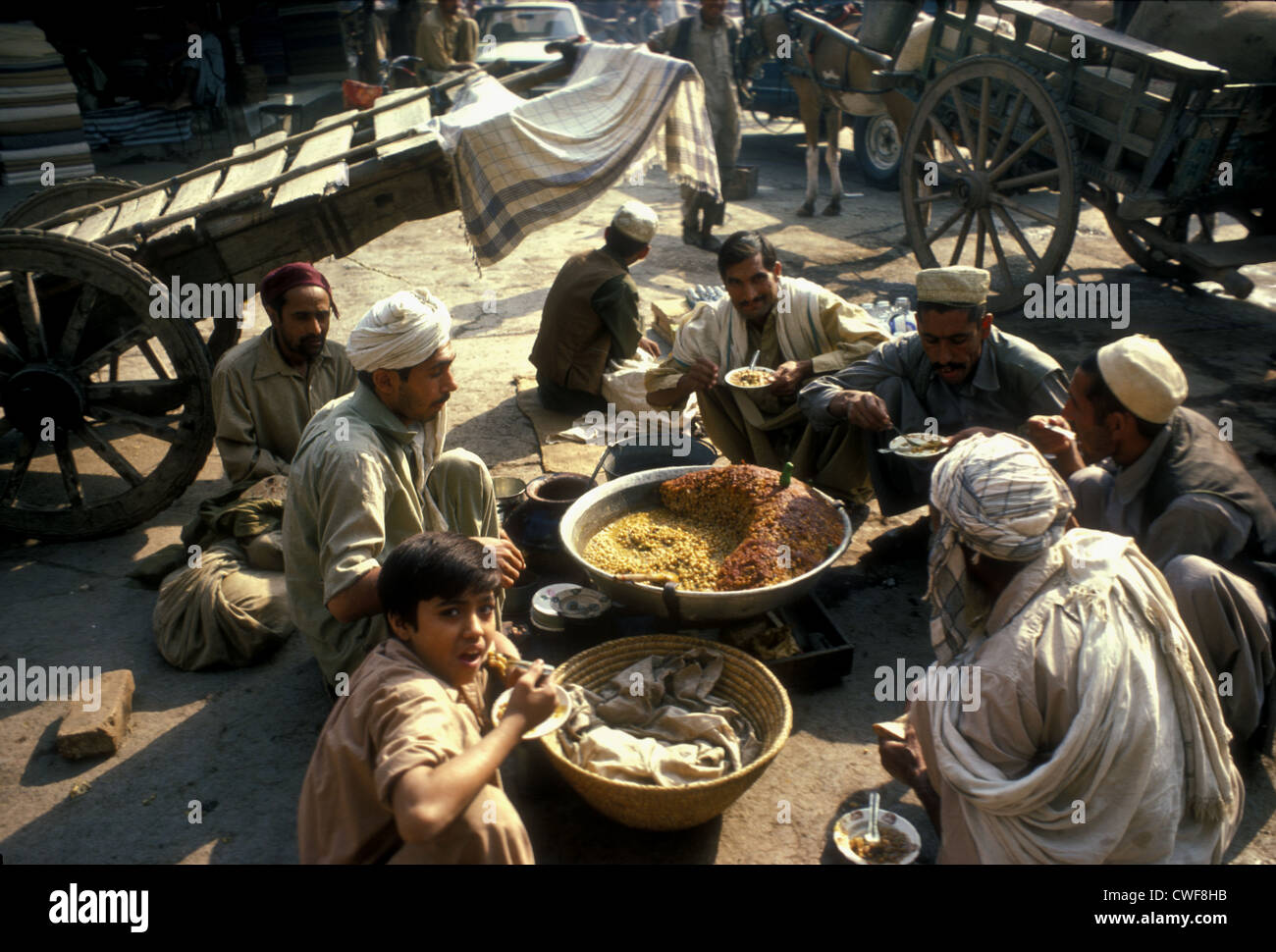 A group of cartdrivers in Peshawar eating lentils, Pakistan Stock