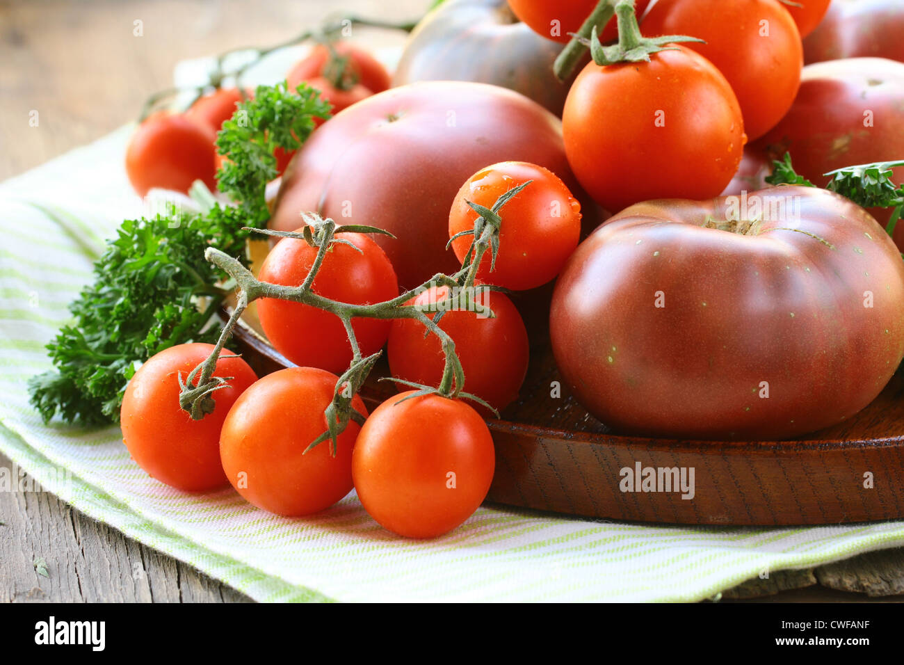 different varieties of tomatoes on wooden plate Stock Photo - Alamy