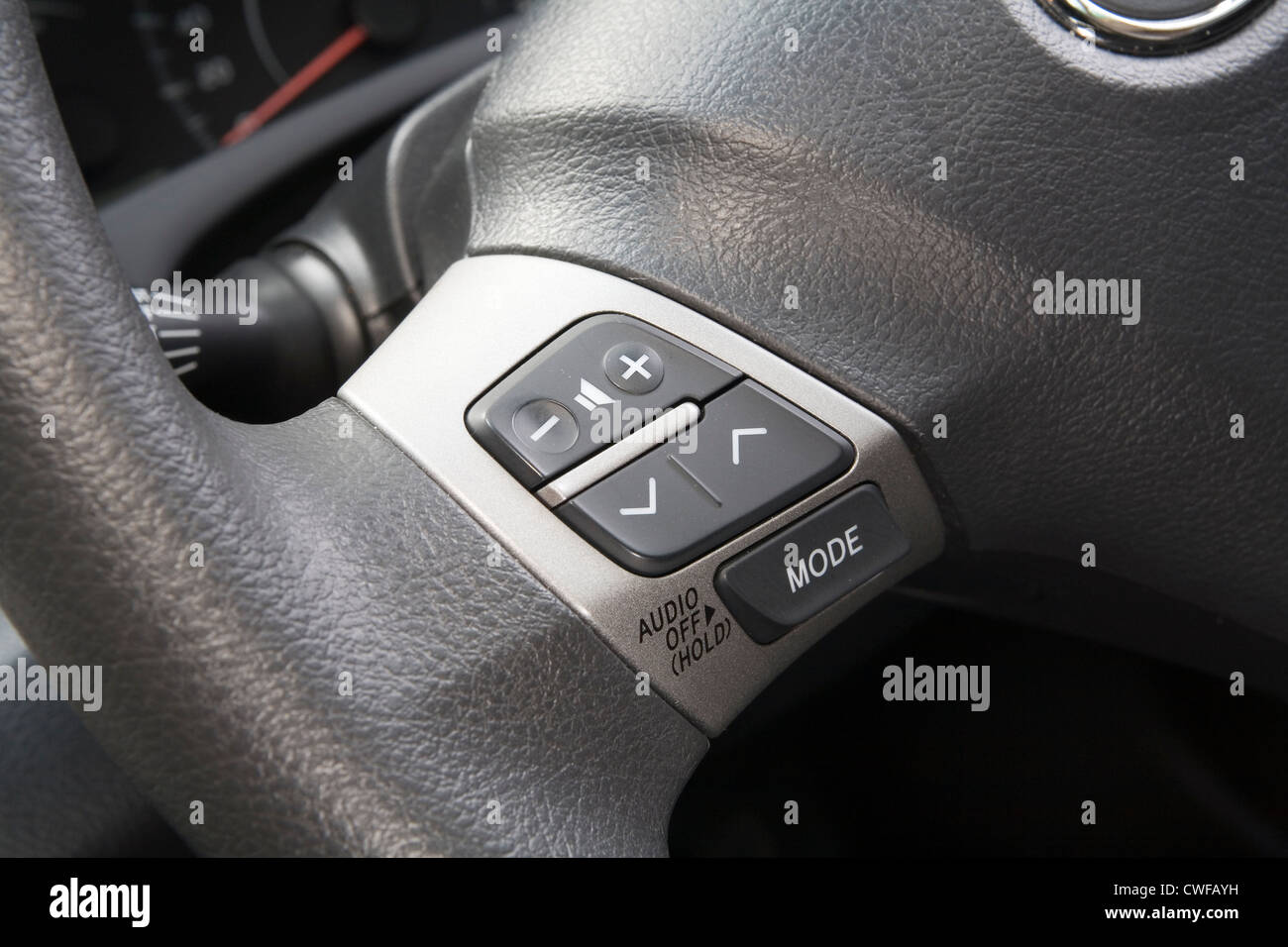Car stereo audio control buttons on the steering wheel of a car Stock