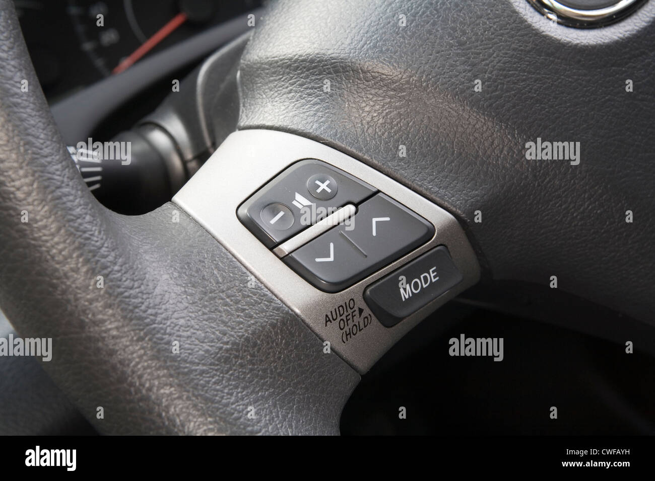 Car stereo audio control buttons on the steering wheel of a car. Stock Photo