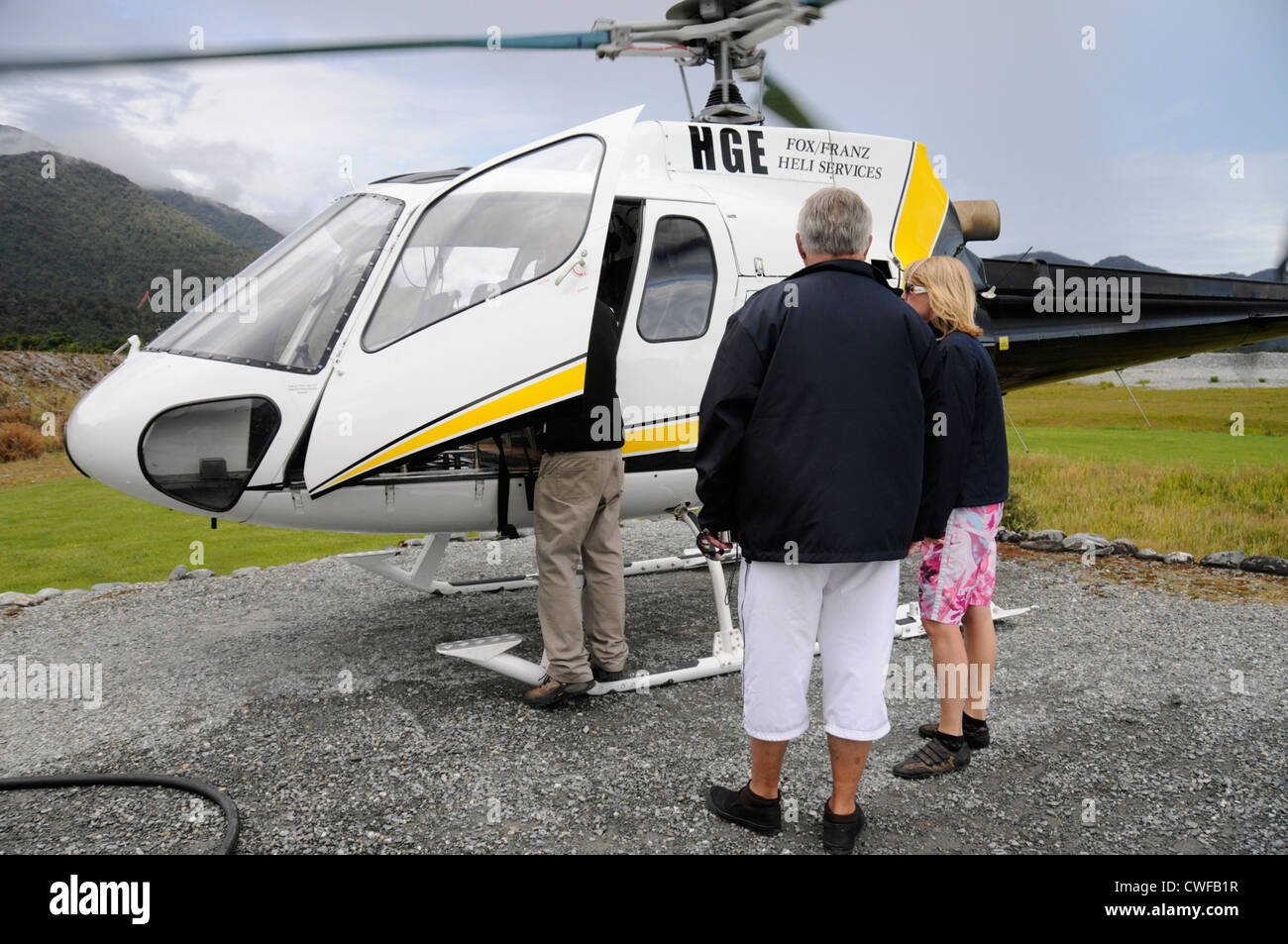 Visitors waiting to board a six-seater helicopter for a sight-seeing trip over Franz Josef glacier in Franz Josef, New Zealand Stock Photo
