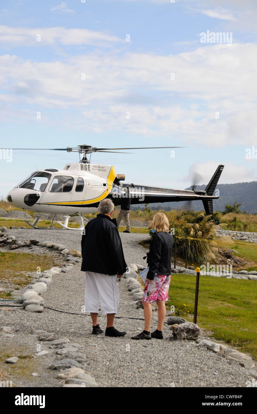 Visitors making their way to board a six-seater helicopter at Franz Josef Glacier in Franz Josef, New Zealand Stock Photo
